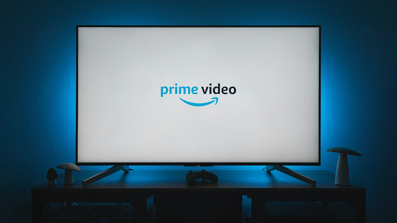 Uma televisão com o logo do Prime Video no centro; o fundo é iluminado por uma luz azulada