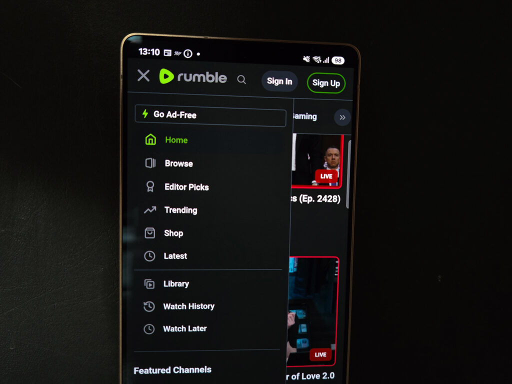 Foto de um celular na tela inicial do site Rumble, muito parecido com o YouTube