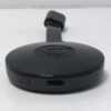 Chromecast de segunda geração em uma mesa. O dispositivo parece um pouco um disco voador com um cabo HDMI pendurado
