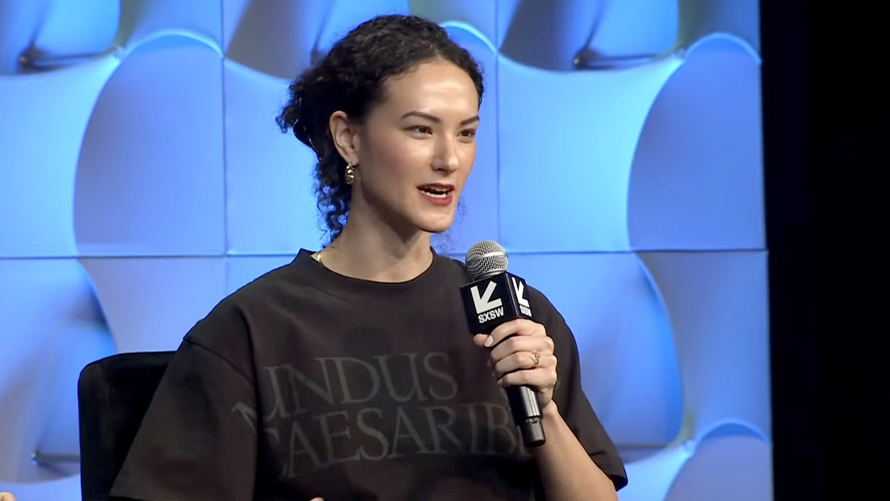 A presidente do Bluesky, Jay Graber, com uma camiseta preta com a frase "Mundus sine Caesaribus" também em preto