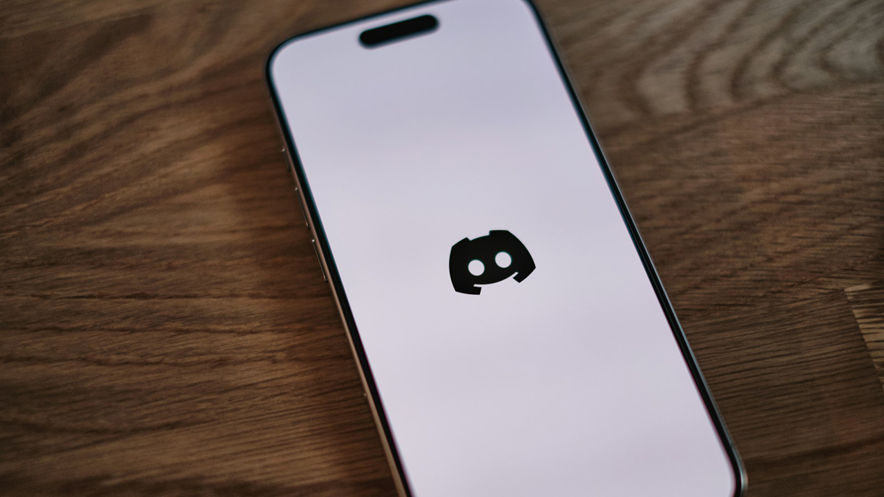 iPhone com a tela branca e o ícone do Discord, uma espécie de mascote com formato de controle de videogame com os olhos onde ficam os controles analógicos