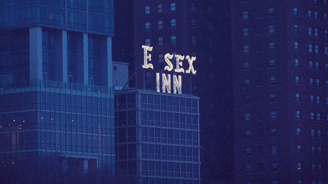 Foto de um prédio com neo escrito E sex Inn