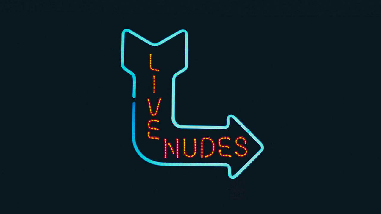 Uma placa em neon com uma seta azul escrito "live nudes"