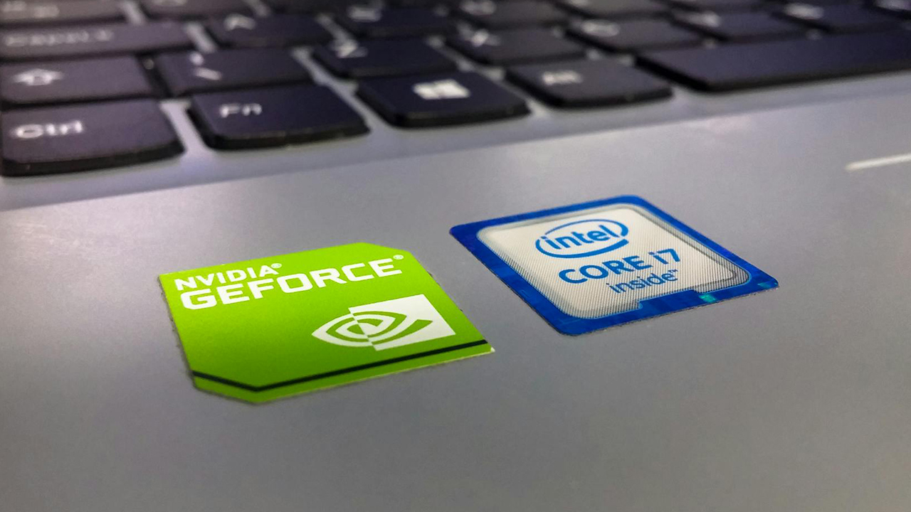 Foto de adesivos da NVIDIA e Intel em um notebook, com o teclado acima, indicando que o dispositivo possui chips das duas empresas