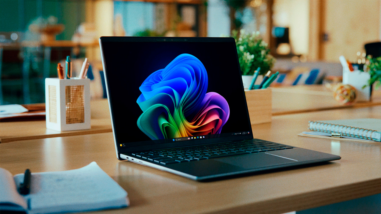 Notebook Dell Latitude 5455 em uma mesa com um papel de parede que parece uma flor nas cores do arco-íris