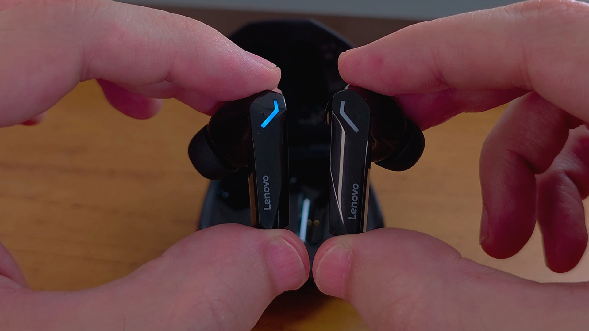 Uma pessoa segura cada lado do fone de ouvido GM2 Pro, com formato de P e linhas mais retas