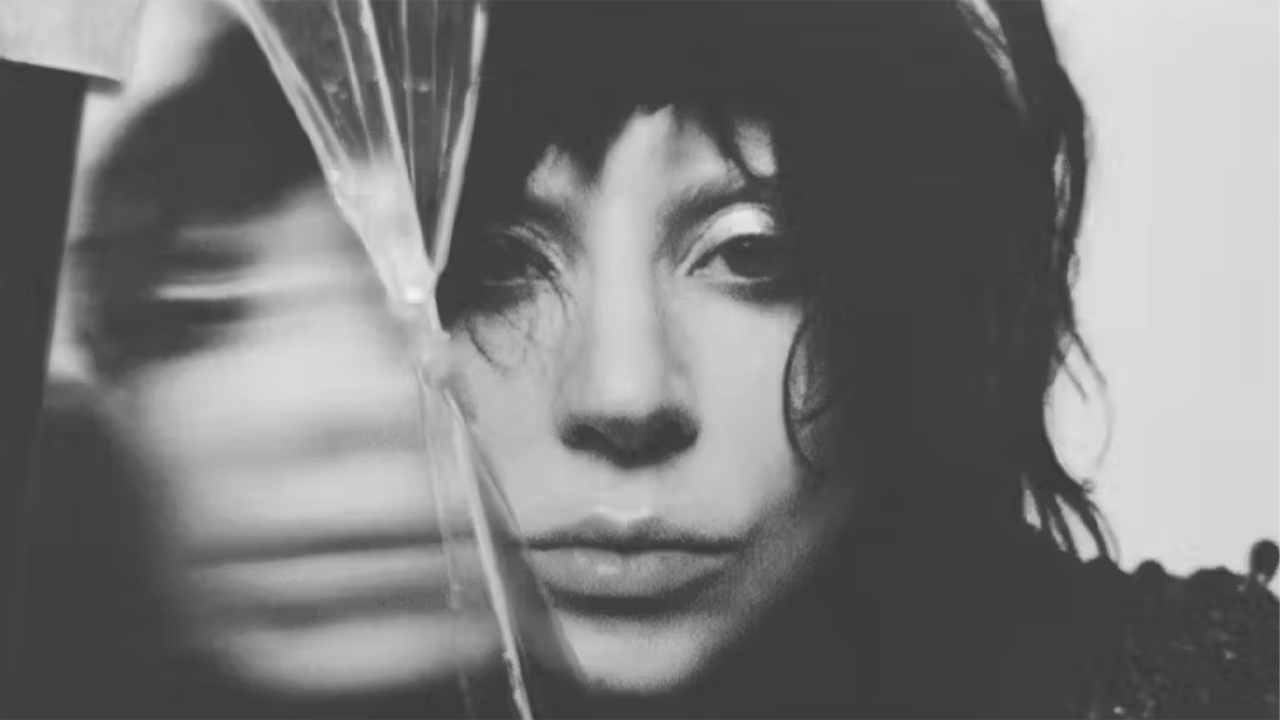 o rosto da cantora Lady Gaga em uma foto estilizada em preto e branco com um reflexo meio borrado no lado esquerdo