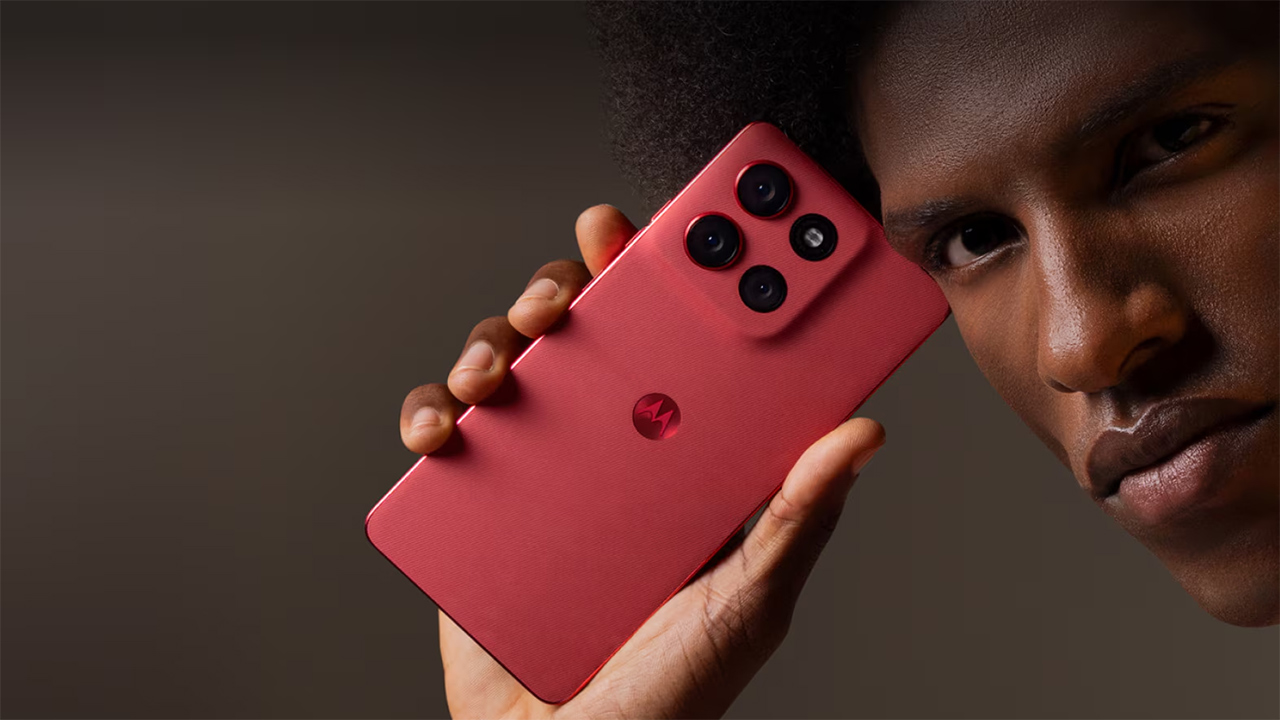 Foto do Moto G86 na cor vermelha segurado por um homem que olha para a câmera com expressão misteriosa