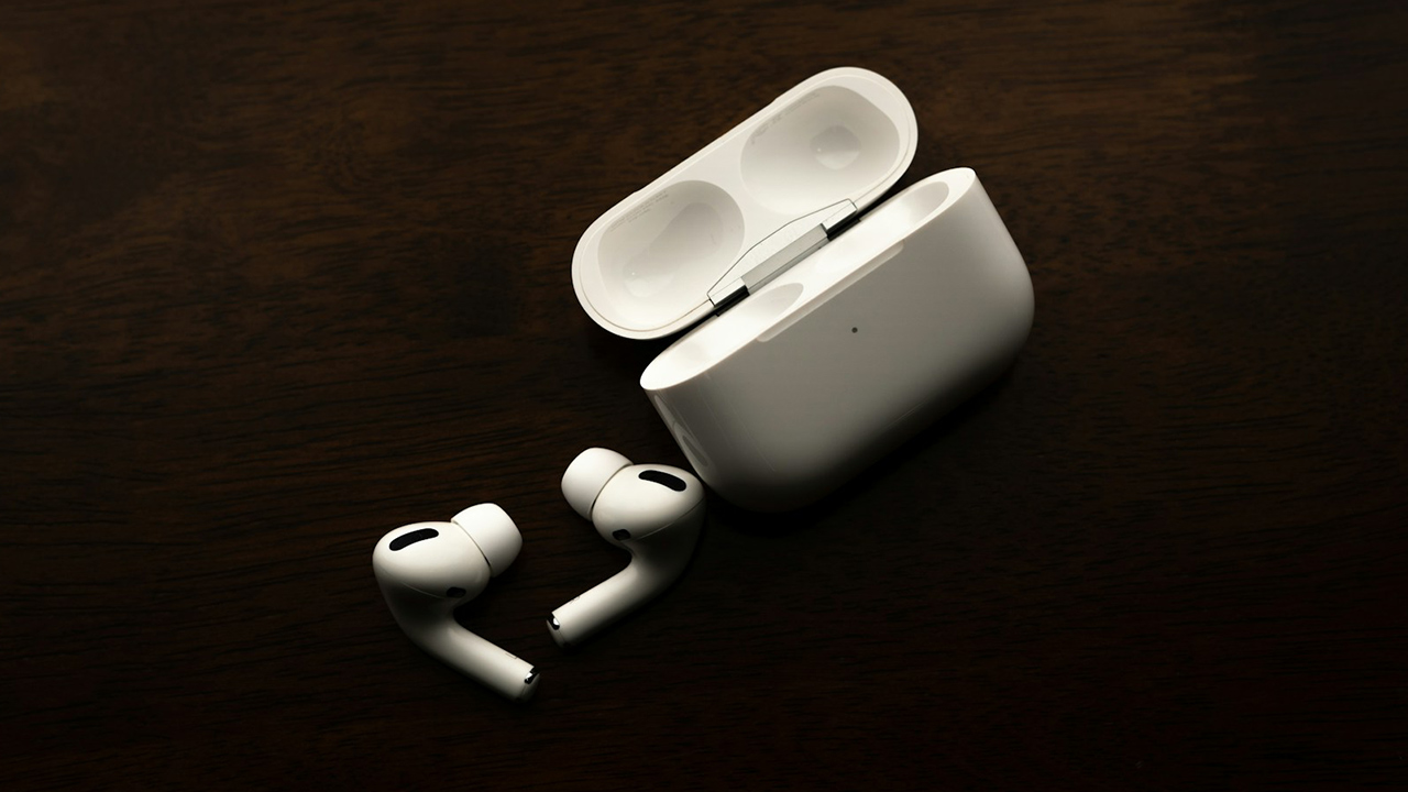 Apple AirPods Pro na cor branca. Os dois fones estão para fora do estojo, que está aberto ao lado deles