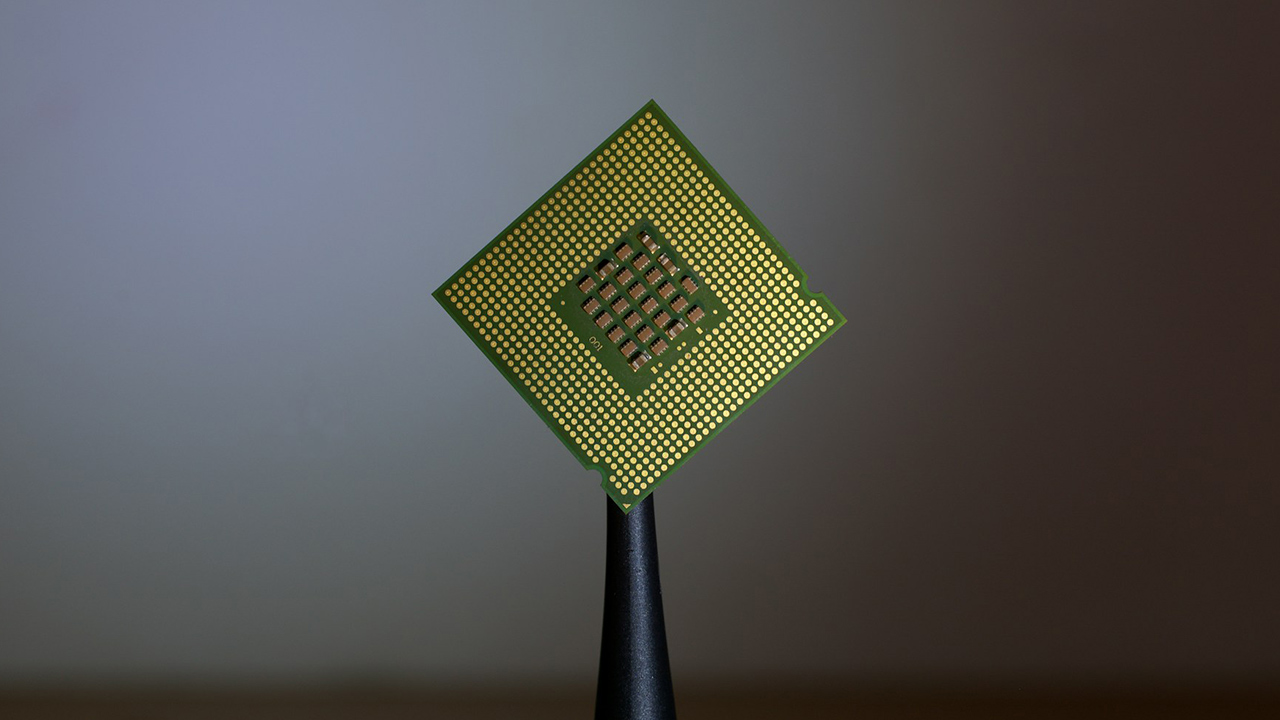 Foto de um chip apoiado em uma espécie de pinça