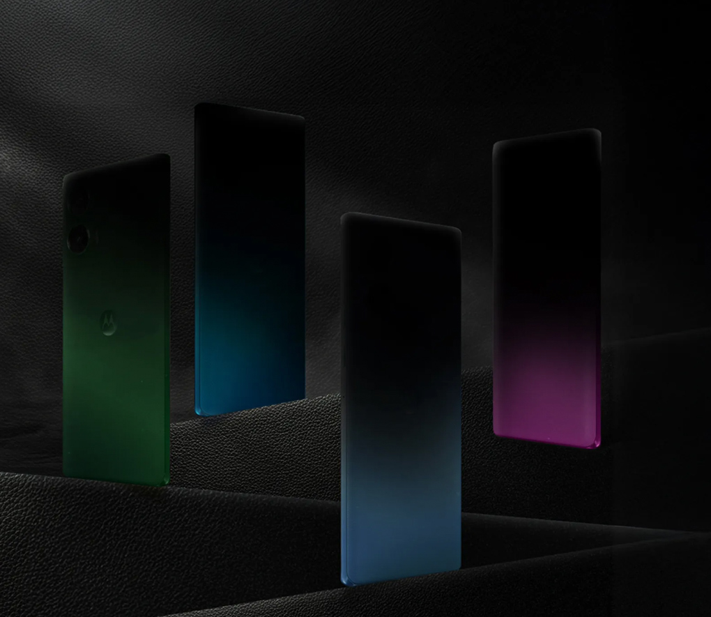 Uma imagem bastante escura mostra apenas a parte inferior das traseiras de quatro celulares, nas cores verde, azul, azul e rosa