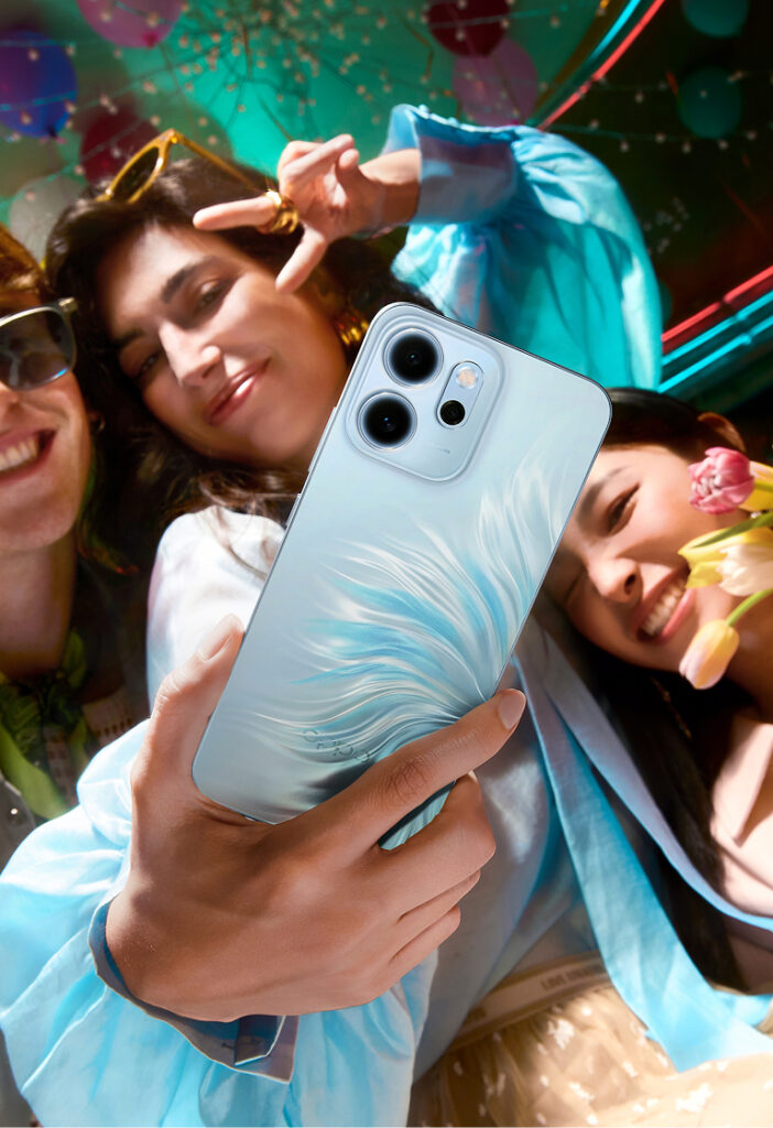 Oppo Reno 14F na cor azul é usado para um trio de mulheres fazerem uma selfie