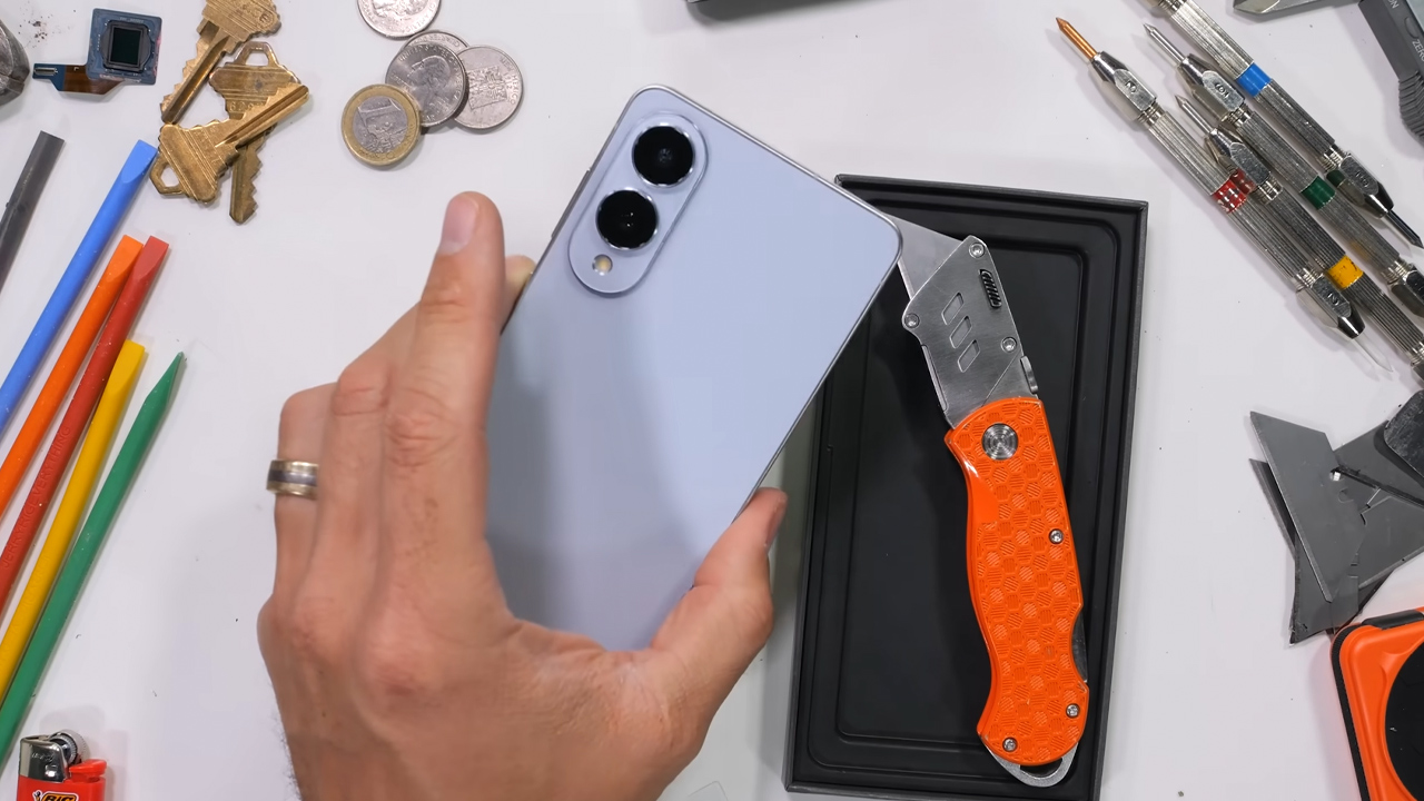 Galaxy S25 Edge na mão de uma pessoa e um estilete na mesa ao lado do celular