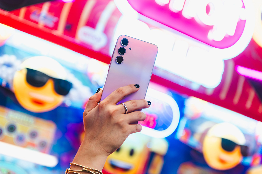 O Galaxy A55 rosa é mostrado por uma pessoa