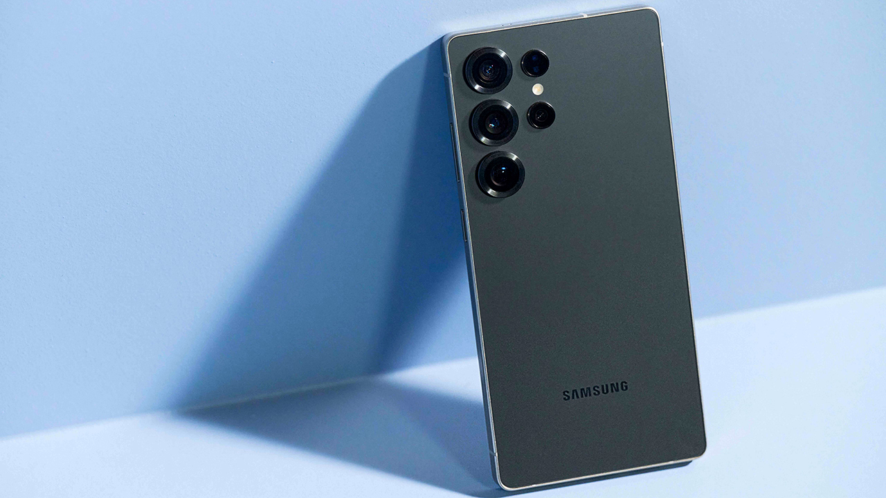 Samsung Galaxy S26 Ultra na cor perto titânio apoiado em uma parede azul