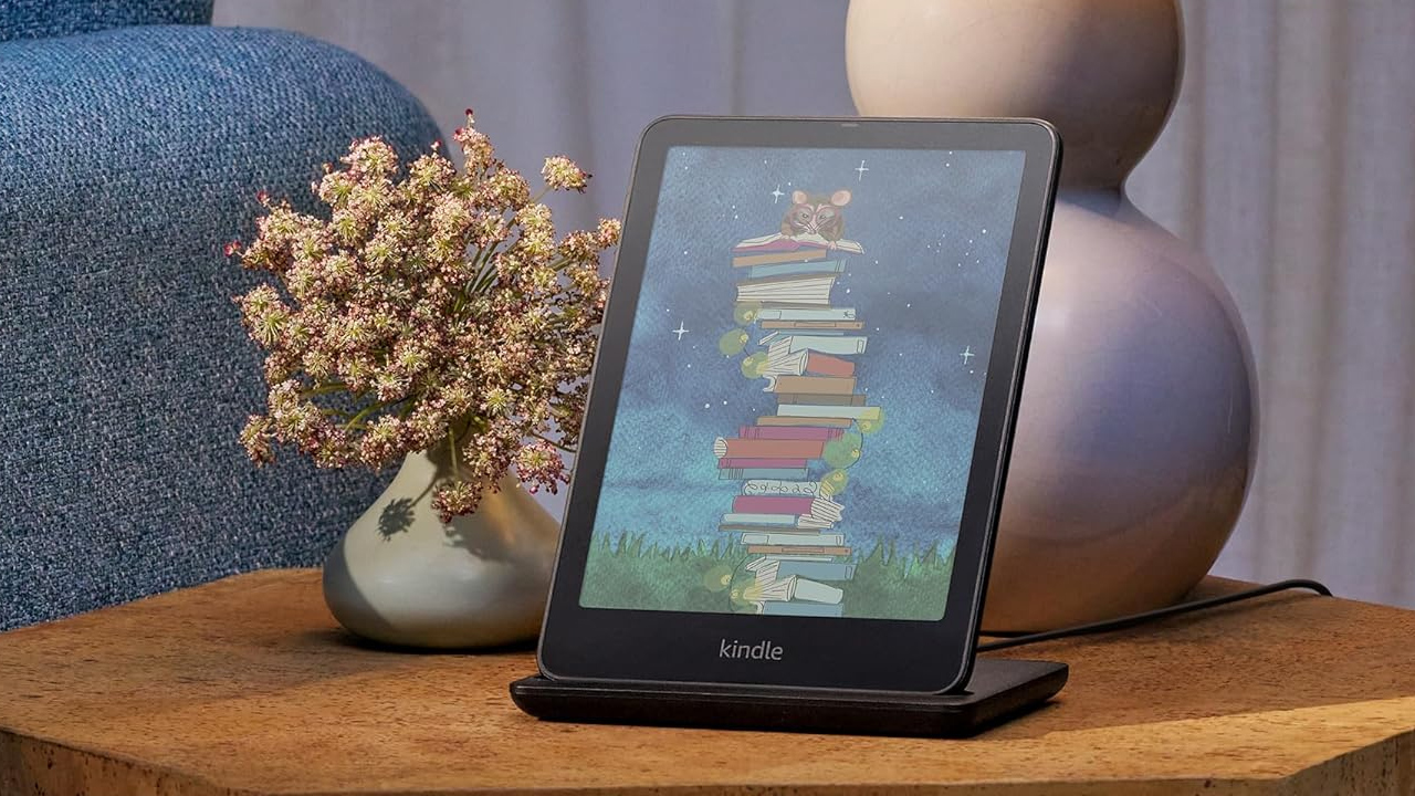 Kindle Colorsoft com a tela colorida em uma ilustração de um rato com óculos em cima de uma pilha de livros
