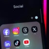 Celular com uma pasta Social com os apps Facebook, Instagram,Threads, X/Twitter, LinkedIn, TikTok e YouTube