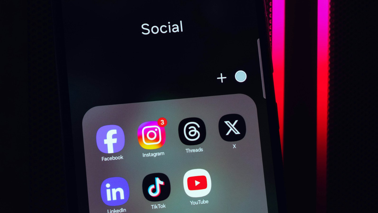 Celular com uma pasta Social com os apps Facebook, Instagram,Threads, X/Twitter, LinkedIn, TikTok e YouTube