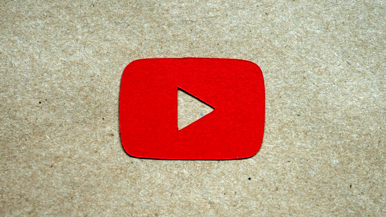 Ícone do YouTube feito em papelão vermelho recortado e colocado sobre um papelão sem tintura