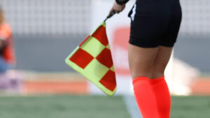 Bandeirinha à beira do campo em uma partida de futebol