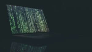 Notebook com uma tela estilo Matrix, com códigos em verde na tela