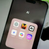 Um iPhone na pasta de IA com os apps ChatGPT, Mistral AI, Claude, Gemini, Copilot e Poe