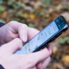 Pessoa segura o celular em uma tela de conversa do WhatsApp