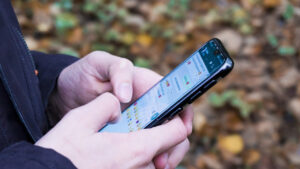 Pessoa segura o celular em uma tela de conversa do WhatsApp